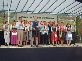15人近くのドイツ人がステージに立ち、そのうちの一人が、マイクの前で話している様子を、正面から撮影した写真