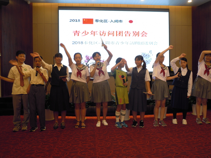 派遣事業に参加している日本人生徒5名と、中国奉化区の生徒5名が、宴会場でお別れの会を楽しんでおり、全員で横一列に並び、腕を左右に振りながら合唱をしている写真。