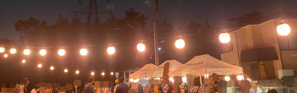 提灯に明かりが灯り、大勢の人でにぎわう夏祭りの夜の会場