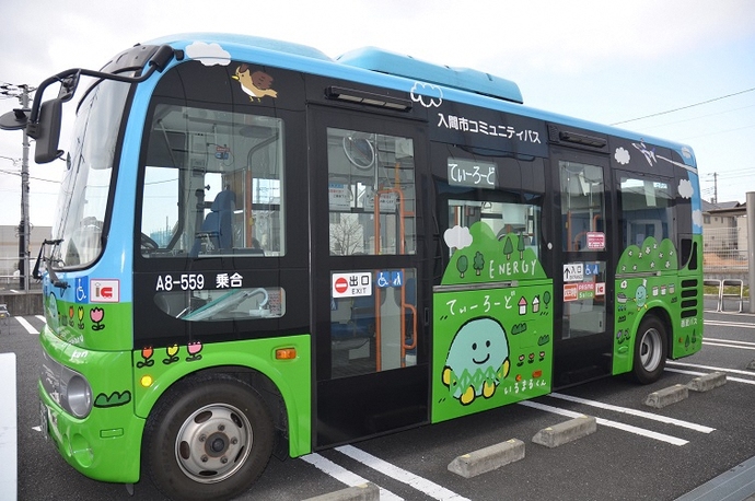 バス全体に草木やキャラクターのイラストが描かれたてぃーろーど「いるまるくん号」の写真