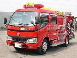 縞模様の消防ホースを搭載した赤い消防ポンプ自動車を撮った写真