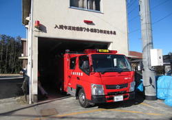 建物から出てくる赤い消防ポンプ自動車を撮った写真