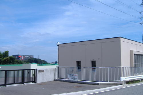 四角い建物が柵でおおわれている東金子配水場の外観の写真