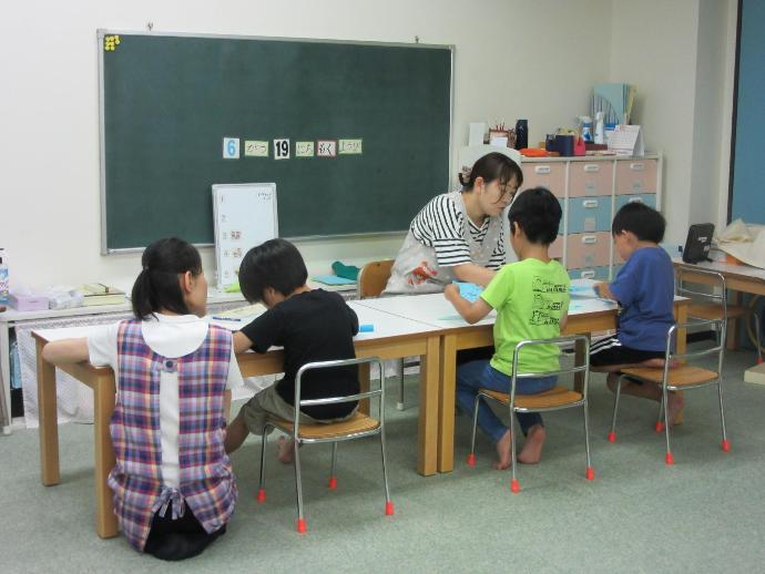 女性2人と男の子4人が工作をしている写真