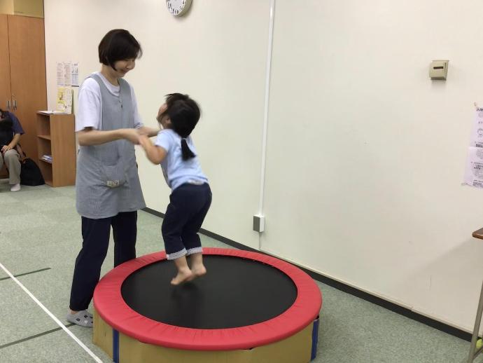 女性と女の子がトランポリンで体を動かしている写真