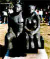 並んで腰掛けている男女の、御影石でできた像の写真