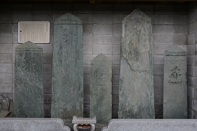 高さの違う5種の石造が横一列に並び、隣に説明看板が貼られている写真