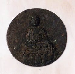 仏様の掘られた黒い円盤の写真