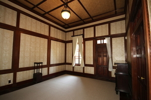 白いカーテンと天井から下げられたランプのある開けた部屋の写真