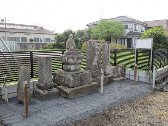 黒いフェンスの前に並ぶ複数の石造物の写真