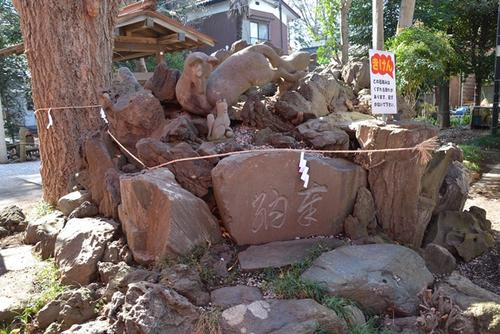 大木と「狐塚」と書かれた石碑と狐の石像に紙垂が付いた写真