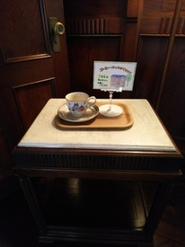 クリップで立てられた紙とティーカップが正方形のテーブルに置かれている写真