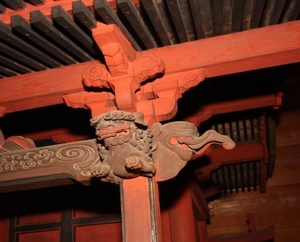 神社の屋根裏を支えている赤い柱の付け根の写真